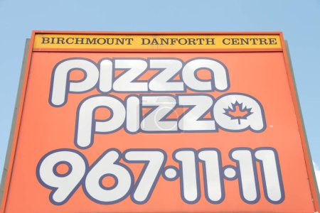 Téléchargez les photos : Pizza pizza 967 1111 panneau bouleau danforth centre, blanc sur orange avec jaune et ciel en arrière-plan, logo - en image libre de droit