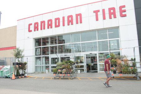 Téléchargez les photos : Devanture de magasin de pneus canadien avec des plantes et le client devant près de l'entrée en été - en image libre de droit
