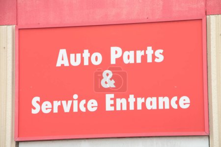 Photo for Auto parts and service entrance sign on hot summer day, white writing on red background, close up - Royalty Free Image