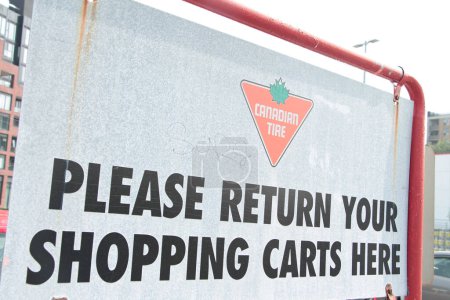 Téléchargez les photos : Pneus canadiens s'il vous plaît retourner vos chariots ici panneau métallique à l'extérieur dans le stationnement avec logo - en image libre de droit