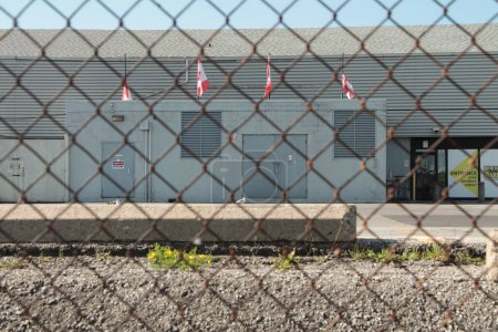 Téléchargez les photos : Quatre drapeaux canadiens du Canada côte à côte depuis le toit avec mur bleu, un drapeau agitant et les autres pas - en image libre de droit