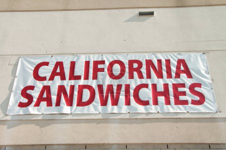Photo for California sandwiches storefront restaurant sign on wall, red writing caption text on white background, close up - Royalty Free Image