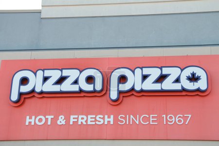 Téléchargez les photos : Pizza pizza chaude et fraîche depuis 1967 logo signe sur le mur du magasin en blanc et orange, tourné directement sur - en image libre de droit