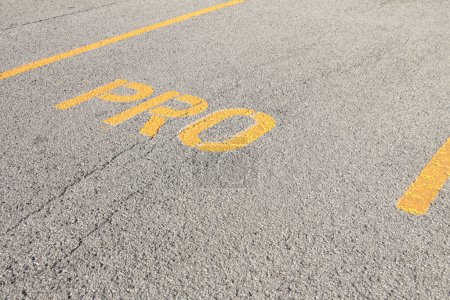 Photo for Parking space in parking lot that says pro in yellow capital letters writing text, close up shot on angle - Royalty Free Image