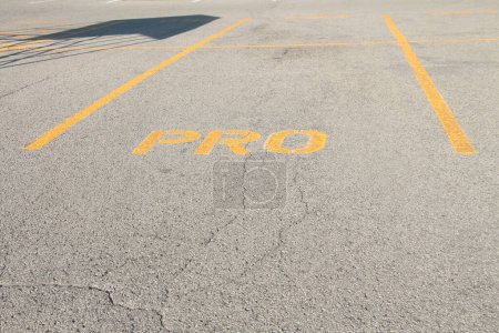 Photo for Parking space in parking lot that says pro in yellow capital letters writing text, close up - Royalty Free Image