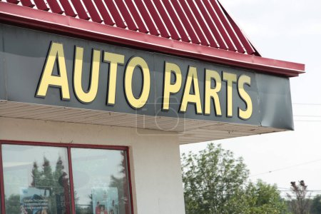 Photo for Auto parts sign facade with roof above and windows below on storefront with parking lot, yellow writing caption text on black background and red roof, close up - Royalty Free Image