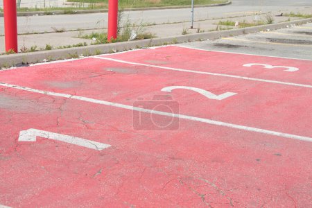 Photo for Three red parking spots spaces with numbers 1 2 3 in each of them side by side in white for pickup with exit entrance in background - Royalty Free Image