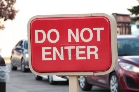 Photo for Do not enter rectangle red and white sign with cars vehicles lined up behind moving toward sign - Royalty Free Image
