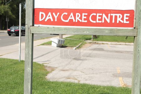 Photo for Day care centre center sign on wood posts with wood frame outside exterior outdoors with road behind - Royalty Free Image
