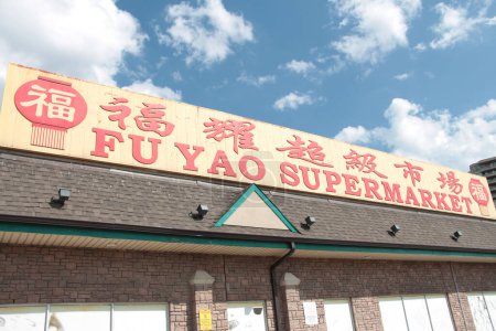 Téléchargez les photos : Fu yao supermarché chinois asiatique épicerie logo horizontal signe cadre du milieu sur le côté sur le magasin en rouge jaune chinois anglais écriture légende texte avec coulds ciel derrière - en image libre de droit