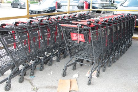 Lebensmittelgeschäft Einkaufswagen Buggys ineinander geparkt innen unter corral Baldachin regen Abdeckung außen außen außen, rot silber