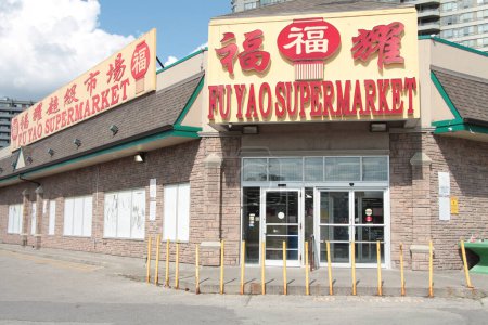 Téléchargez les photos : Fu yao supermarché chinois asiatique épicerie entrée avant avec logo en rouge jaune chinois anglais écriture légende texte avec coulds ciel derrière - en image libre de droit