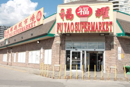 Téléchargez les photos : Fu yao supermarché chinois asiatique épicerie entrée avant avec portes ouvertes avec logo en rouge jaune chinois anglais écriture légende texte avec coulds ciel derrière - en image libre de droit