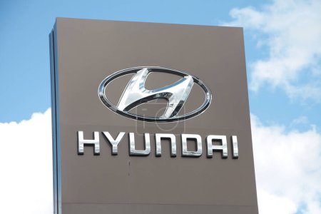 Photo for Hyundai silver logo sign on gray pillar outside outdoors exterior with clouds sky behind, close up - Royalty Free Image