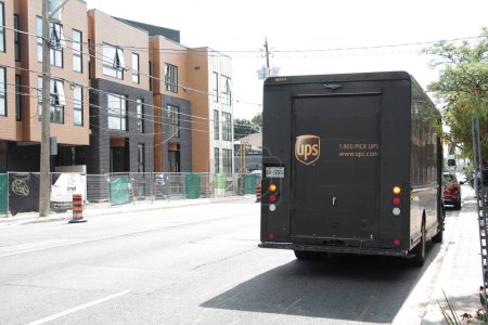 Photo for Ups logistics company franchise delivery truck van vehicle parked at side of road street in summer - Royalty Free Image