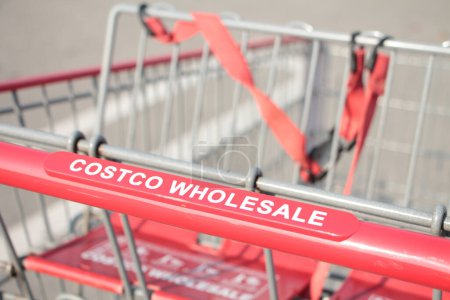 Photo for Costco wholesale red silver shopping cart close up on costco wholesale writing caption text on handle close up in summer shot on angle - Royalty Free Image