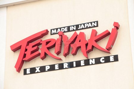 Foto de Teriyaki experience made in japan restaurante store franchise chain logo sign on store building wall in red black white on beige, close up - Imagen libre de derechos