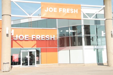 Photo for Joe fresh brand company store building front entrance with banner flag sign horizontal rectangle on metal bars orange background white writing exterior outside - Royalty Free Image