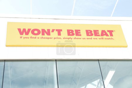 Photo for Wont be beat if you find a cheaper price simply show us and we will match writing caption text sign on store above windows in red on yellow on white exterior outside - Royalty Free Image