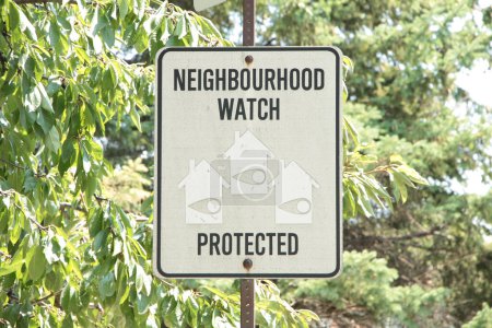 Photo for Neighbourhood watch protected writing caption text rectangle sign on post with tree behind and faced picture illustrations of homes houses with eyes on in them, black and white - Royalty Free Image