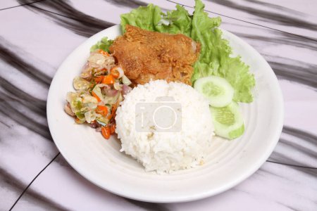 Foto de Un plato de arroz con pollo frito y verduras - Imagen libre de derechos