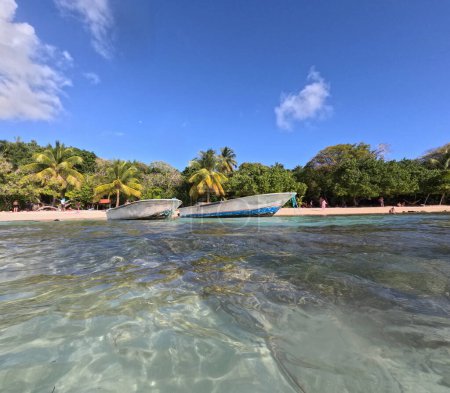 playa de petit havre con dos barcos vistos desde el mar claro, isla caribeña de Guadalupe