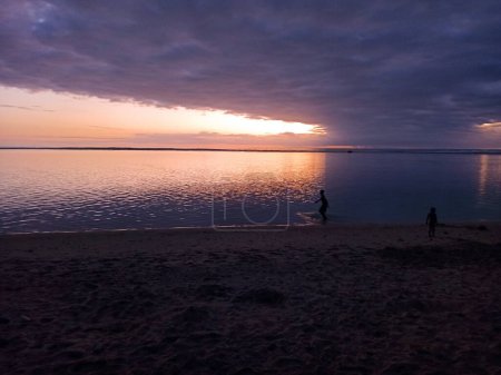 Kids playing on the beach at dusk in Saint Gilles, Reunion, France