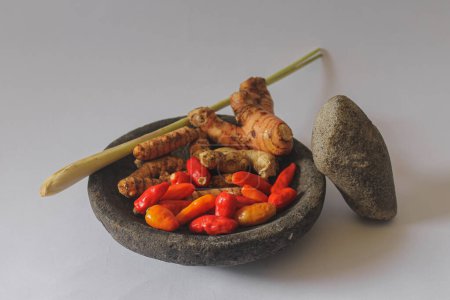 Photo for Fresh food ingridients on the stone mortar, there are red chili, turmeric, ginger and more traditional spices - Royalty Free Image