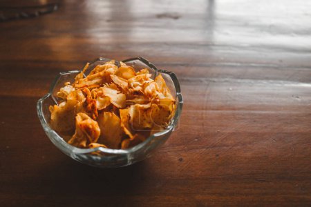 Photo for Close up meal photography, hot cassava chips on the glass bowl and wooden table - Royalty Free Image