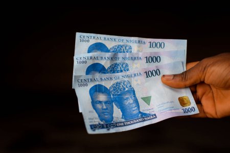 Foto de Mano sosteniendo dinero. Billetes de moneda nigeriana en África - Imagen libre de derechos