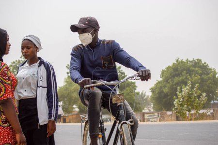 Foto de Vimtim, estado de Adamawa, Nigeria: 1 de marzo de 2023 - Montar en bicicleta por una carretera asfaltada y asfaltada. - Imagen libre de derechos