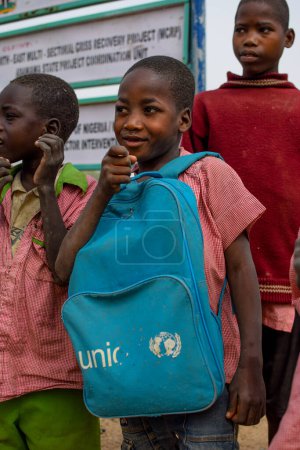 Foto de Abuja, Nigeria - 6 de enero de 2023: Retrato de un niño africano aprendiendo en una comunidad rural. Niños africanos sonrientes con uniforme escolar. Educación primaria en aldeas africanas. - Imagen libre de derechos
