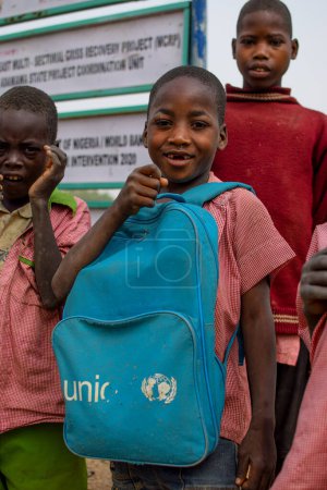 Foto de Abuja, Nigeria - 6 de enero de 2023: Retrato de un niño africano aprendiendo en una comunidad rural. Niños africanos sonrientes con uniforme escolar. Educación primaria en aldeas africanas. - Imagen libre de derechos