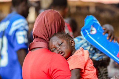 Téléchargez les photos : Jos, Nigéria - 12 mai 2021 : Mère africaine avec son enfant. Maman allaitant bébé. - en image libre de droit