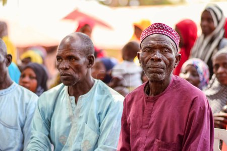 Téléchargez les photos : Abuja Nigeria - 26 février 2023 : Sensibilisation de la communauté à la Covid 19, Santé et hygiène de l'eau. Africains assis, faisant la queue et attendant des soins médicaux gratuits. Processus électoraux en Afrique. - en image libre de droit