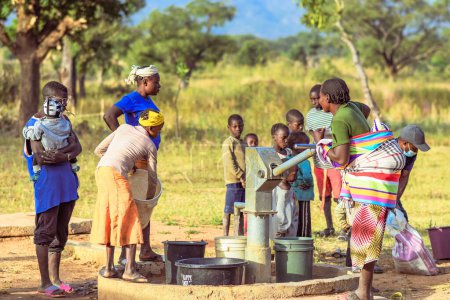 Téléchargez les photos : Talata, État du Plateau, Nigéria - 2 avril 2023 : Des Africains autochtones récupèrent de l'eau d'une pompe à main indienne nouvellement construite. Les membres de la communauté vont chercher de l'eau pour usage domestique - en image libre de droit
