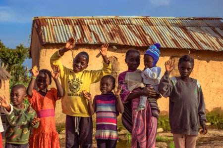 Foto de Abuja, Nigeria - 6 de marzo de 2023: Niños africanos se divierten. Momentos tontos con niños africanos locales al aire libre bajo un soleado cielo azul. - Imagen libre de derechos
