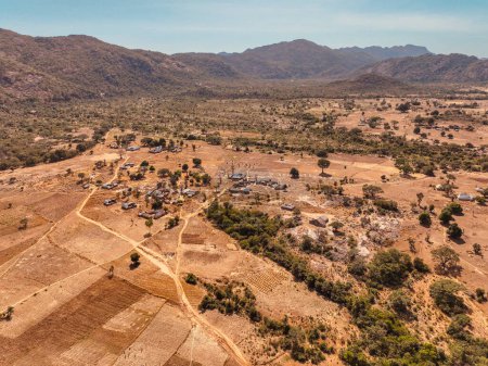 Téléchargez les photos : Établissement Tournage d'un drone d'une colonie rurale africaine entourée de montagnes. Sous Développement dans les communautés rurales africaines - en image libre de droit