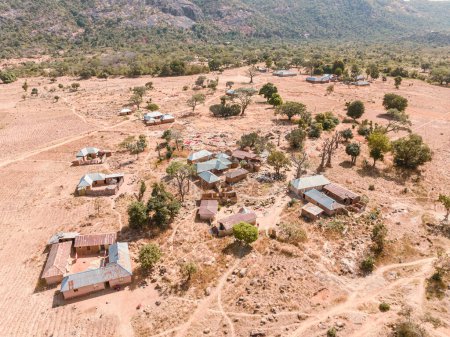 Foto de Establecimiento Drone Shot of an African Rural Settlement Rodeado de montañas. En desarrollo en las comunidades rurales africanas - Imagen libre de derechos