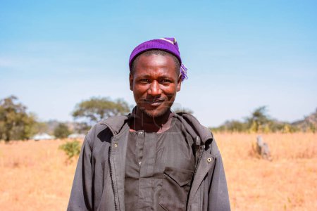 Téléchargez les photos : Jos, Nigéria - 2 avril 2023 : Un éleveur Fulani africain pose à la caméra pour un moment franc. Homme nord-africain souriant - en image libre de droit