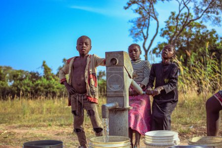 Foto de Karara, Nasarawa State, Nigeria - May 5, 2021:Newly Constructed Indian Hand Pump Borewell in a Rural Community in Africa. Running Water from a Community Borehole Water Point - Imagen libre de derechos