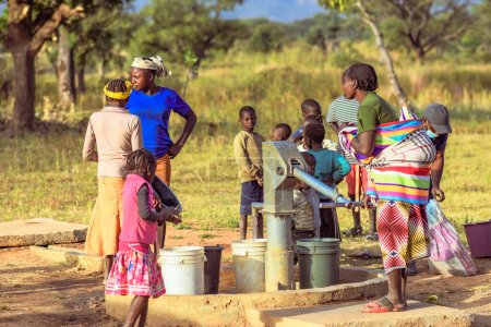 Foto de Talata, Plateau State - 2 de abril de 2023: Los africanos indígenas buscan agua de una bomba de mano india recién construida. Miembros de la comunidad que buscan agua para uso doméstico - Imagen libre de derechos