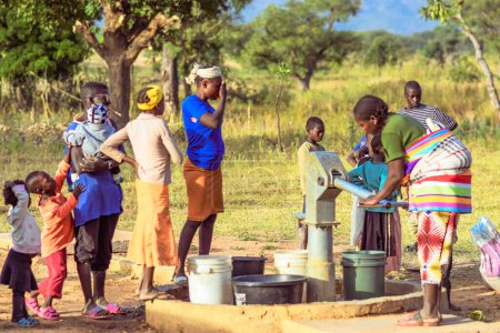Téléchargez les photos : Talata, État du Plateau - 2 avril 2023 : Des Africains autochtones récupèrent de l'eau d'une pompe à main indienne nouvellement construite. Les membres de la communauté vont chercher de l'eau pour usage domestique - en image libre de droit