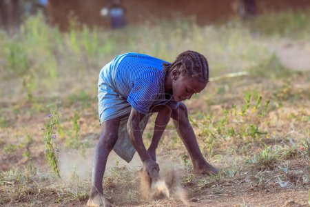 Téléchargez les photos : Abuja, Nigéria - 01 mars 2022 : Le travail des enfants dans les communautés africaines. Enfant travaillant dans une ferme - en image libre de droit