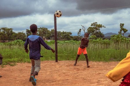 Photo for Lagos, Nigeria - March 02, 2023: African Children Playing Football on a Sandy Field. Sport Activities in Rural Communities in Africa. Street Football among Local African Kids. - Royalty Free Image