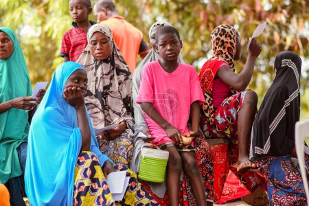 Foto de Abuja, Nigeria - 09 de enero de 2023: Pacientes africanos que reciben consulta al aire libre en una aldea. Sesión de asesoramiento individual con un terapeuta en una comunidad local. - Imagen libre de derechos