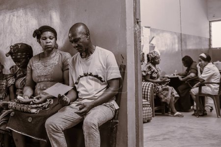 Foto de Abuja, Nigeria - 09 de enero de 2023: Pacientes africanos que reciben consulta al aire libre en una aldea. Sesión de asesoramiento individual con un terapeuta en una comunidad local. - Imagen libre de derechos