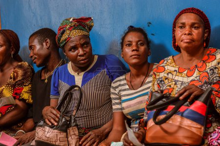 Téléchargez les photos : Abuja, Nigéria - 10 février 2021 : Africains assis, faisant la queue et attendant des soins médicaux gratuits et de l'attention dans une communauté rurale. Les gens s'inscrivent pour voter aux élections. Exercice de campagne politique - en image libre de droit