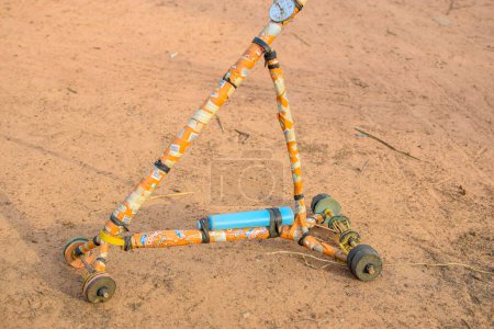 Téléchargez les photos : DIY Craft Invention Made in Africa. Scooter local fabriqué à partir d'articles recyclés. Jouet à faible émission pour les enfants dans les communautés rurales au Nigeria, Afrique de l'Ouest. - en image libre de droit