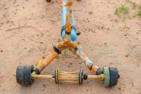 Foto de Invención artesanal de bricolaje hecha en África. Scooter local hecho de artículos reciclados. Juguete de baja emisión para niños en comunidades rurales en Nigeria, África Occidental. - Imagen libre de derechos